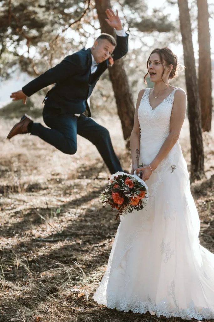Hochzeitsfotograf Dresden Braut lacht und mann springt im hintergrund in die hoehe