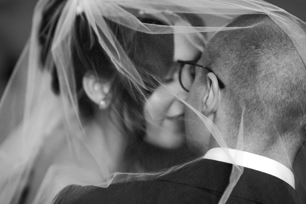 Hochzeitsfotograf Potsdam Das Brautpaar küsst sich durch dem Schleier und sie lächelt lieb
