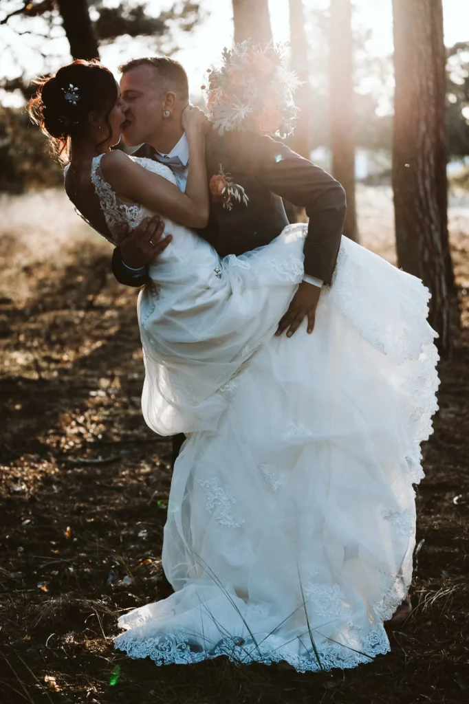 Hochzeitsfotograf Potsdam Das Brautpaar küsst sich und sie hebt das Bein dabei