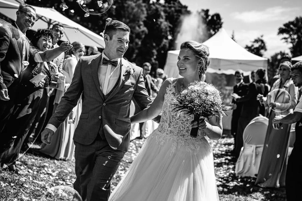 Hochzeitsfotograf Potsdam Das Brautpaar läuft hand in Hand durch ein spalier