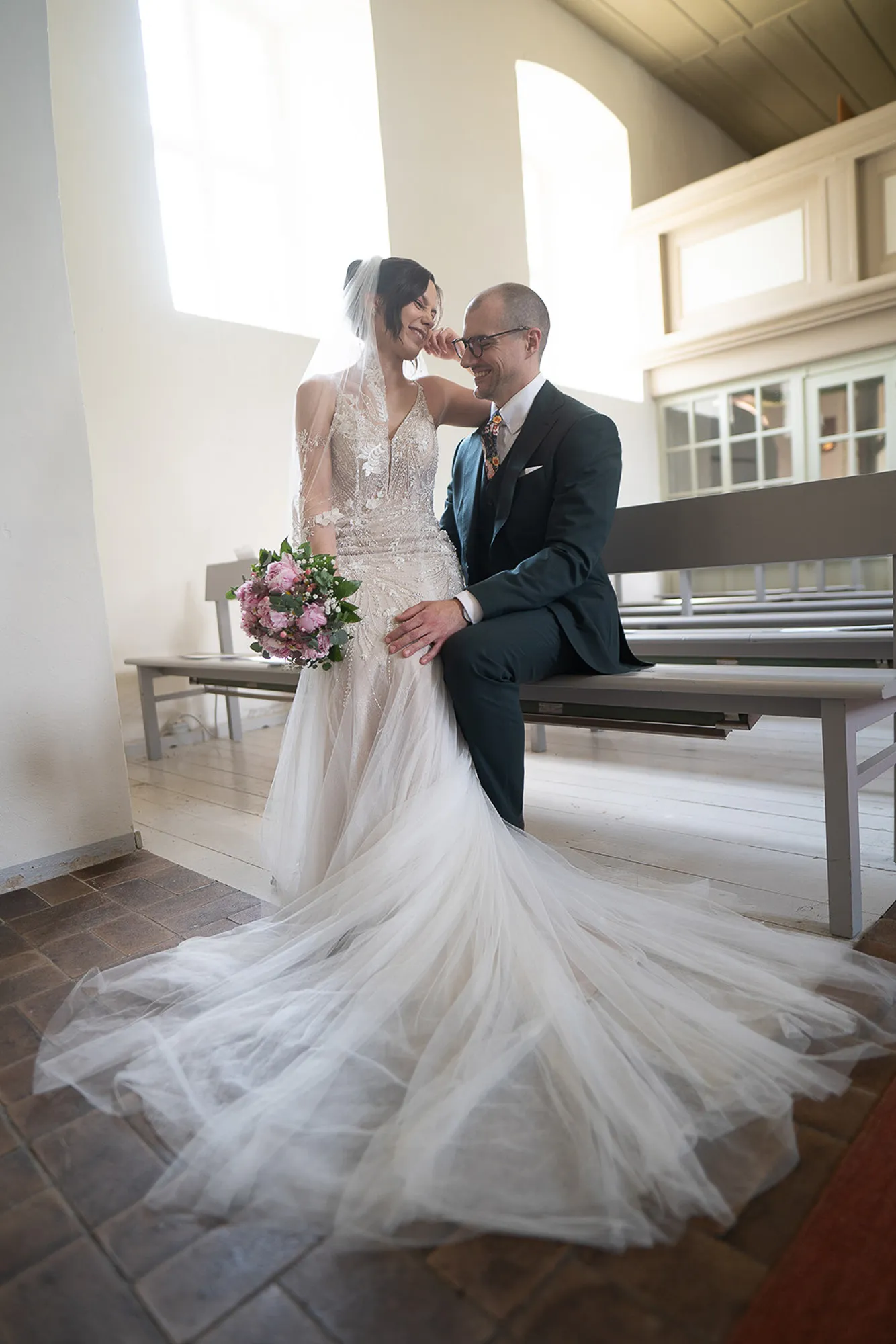 Hochzeitsfotograf Potsdam Die Braut sitzt auf dem Schoß des Bräutigams in einer Kirche