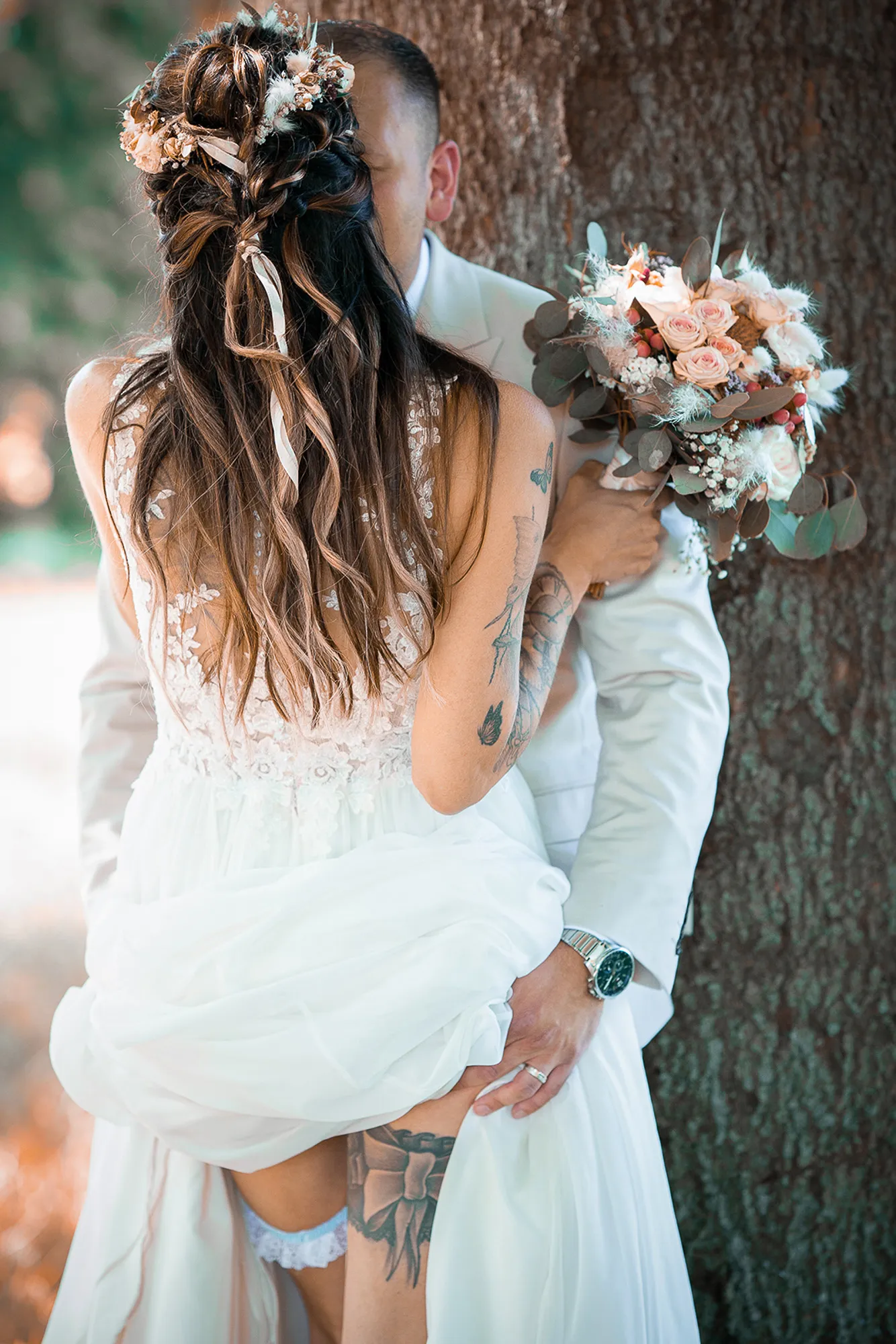 Hochzeitsfotograf Potsdam Das Brautpaar steht am Baum und hebt das Kleid hoch